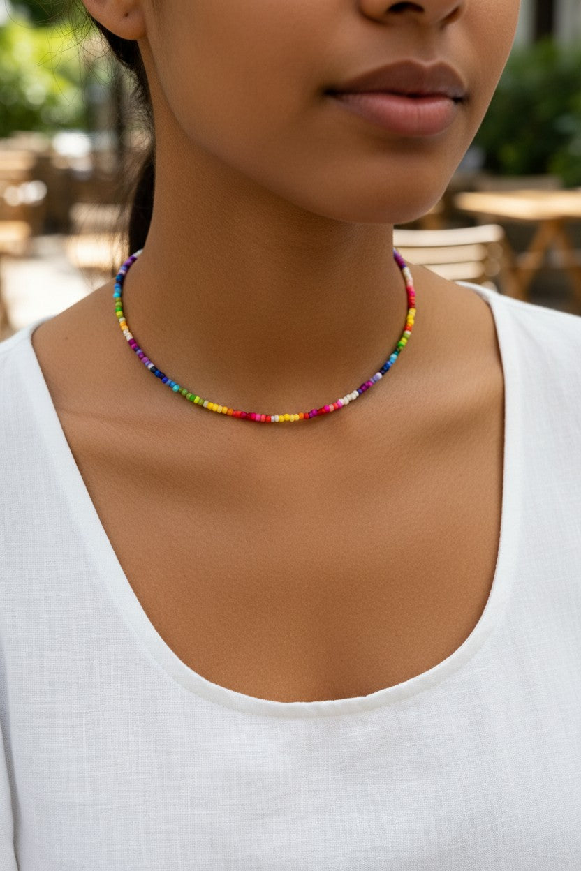 Woman wearing a colorful beaded necklace with a blurred outdoor background