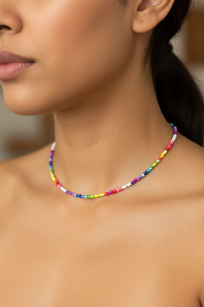 Close-up of a person wearing a colorful beaded necklace on a neutral background