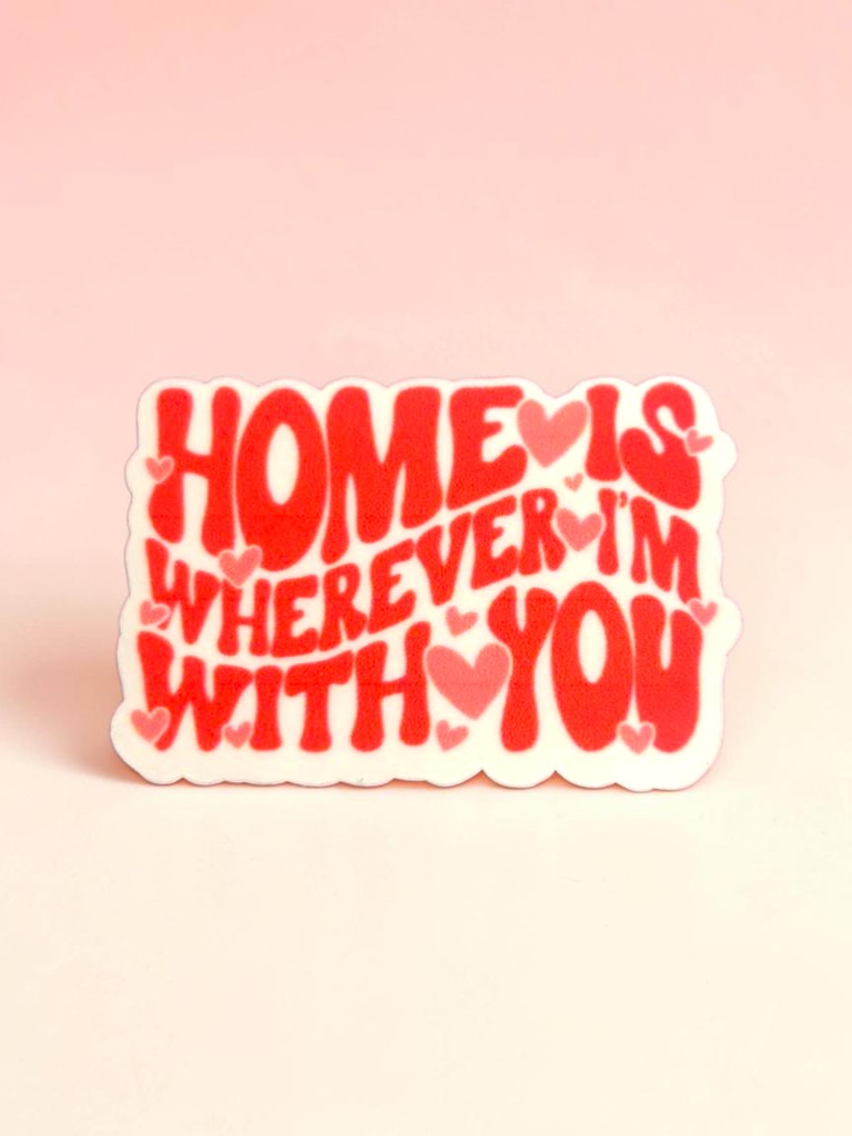 Permanent sticker with red text 'HOME IS WHEREVER I'M WITH YOU' on a pink background