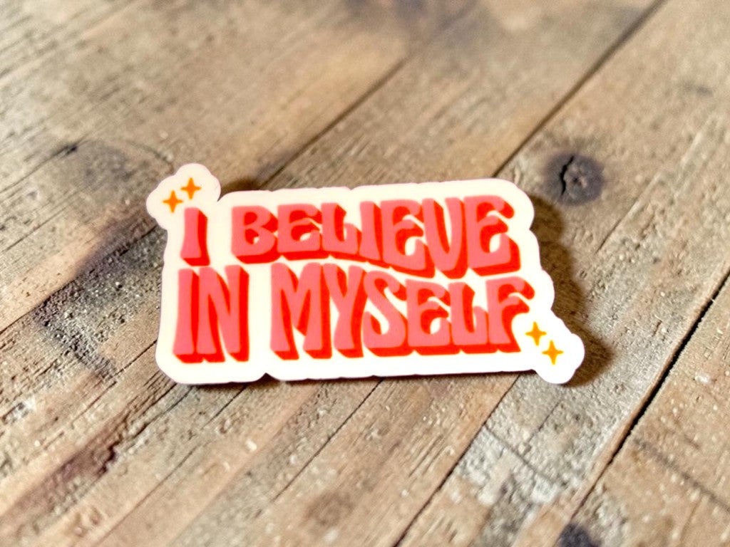 Sticker with 'I Believe In Myself' text on a wooden surface