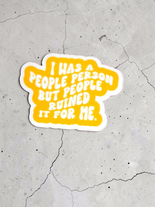 Permanent sticker with " I was a people person, but people ruined for me" text on a concrete background