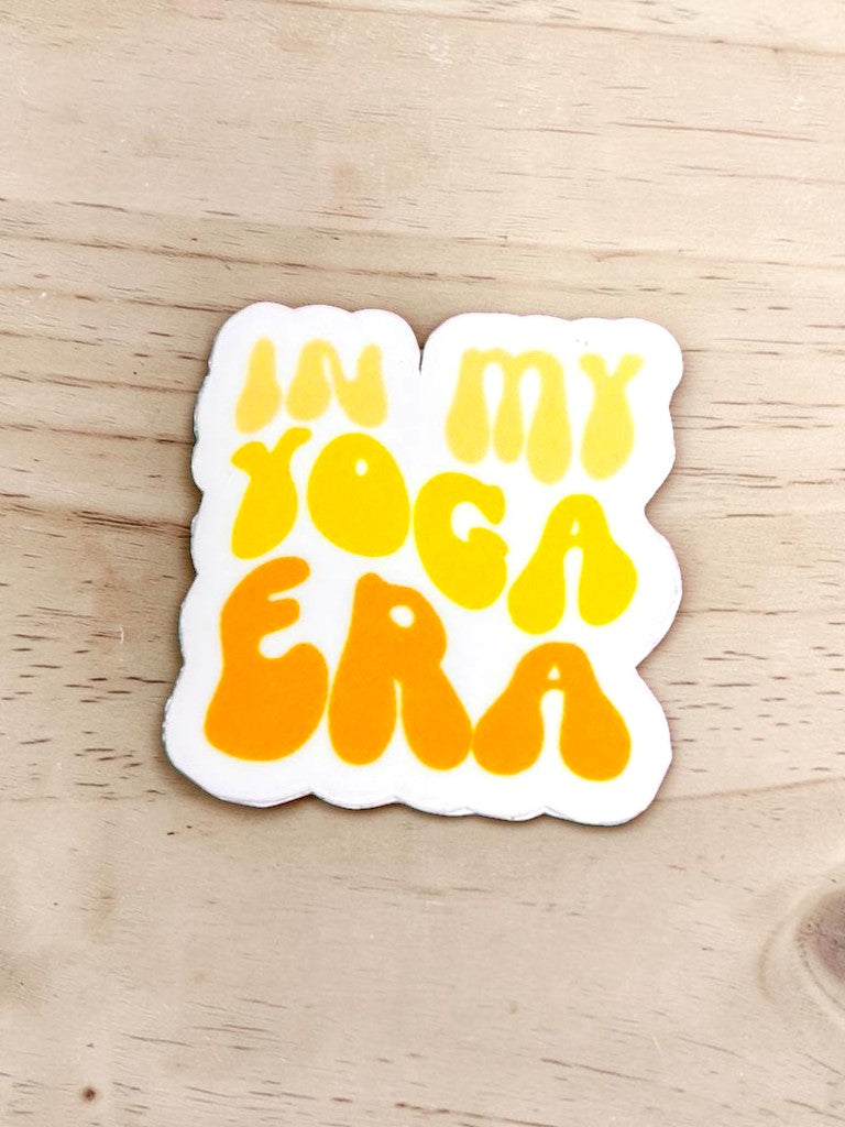 Permanent sticker with 'In my yoga era' text on a wooden surface