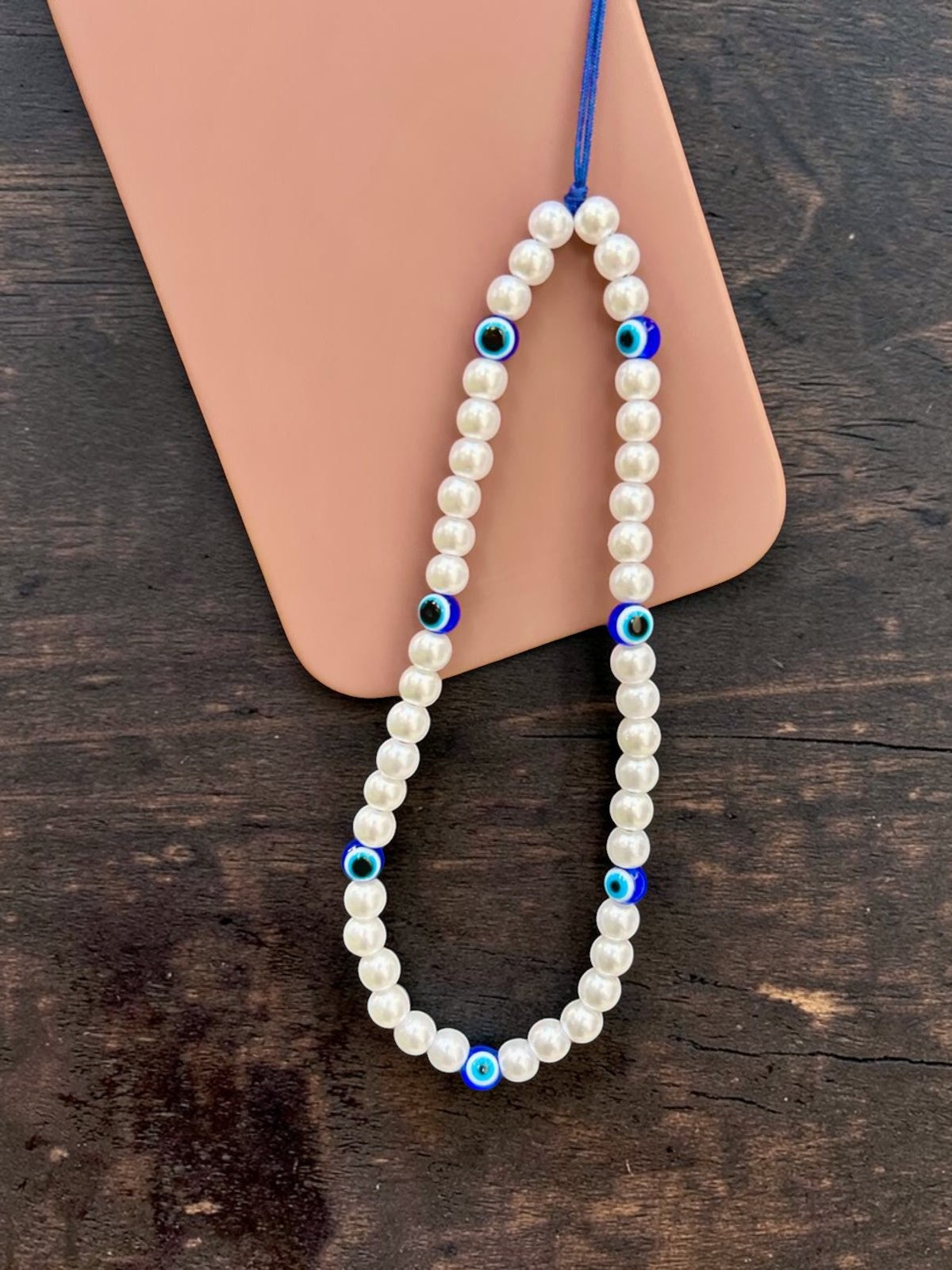 close up eye pearl phone strap beaded charm detail aesthetic design