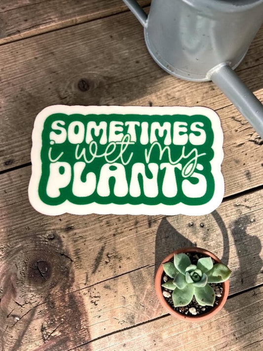 Permanent Sticker with 'Sometimes I wet my plants' text on a wooden surface with a potted plant and watering can.