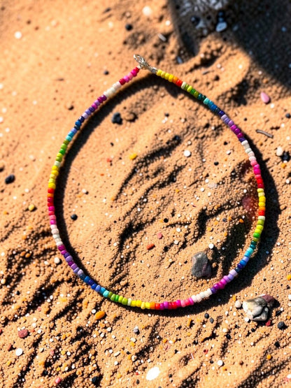 Colorful beaded necklace on a sandy surface